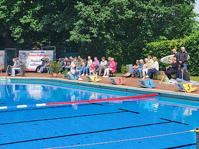 Zuschauer sitzen um Schwimmbecken