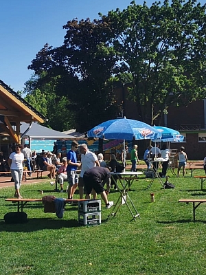 Menschen sitzen auf Bänken auf einer Wiese