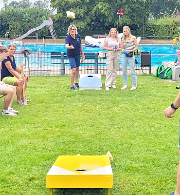 Frau spielt Cornhole mit Zuschauern